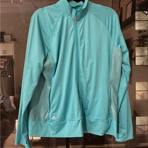Teal blue Adidas jacket with reflective logo and zippered pockets